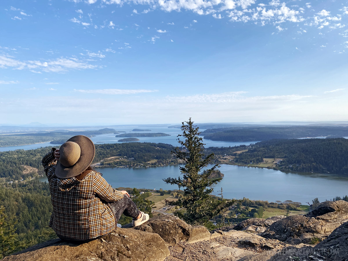 woman enjoying view of water from a mountaintop