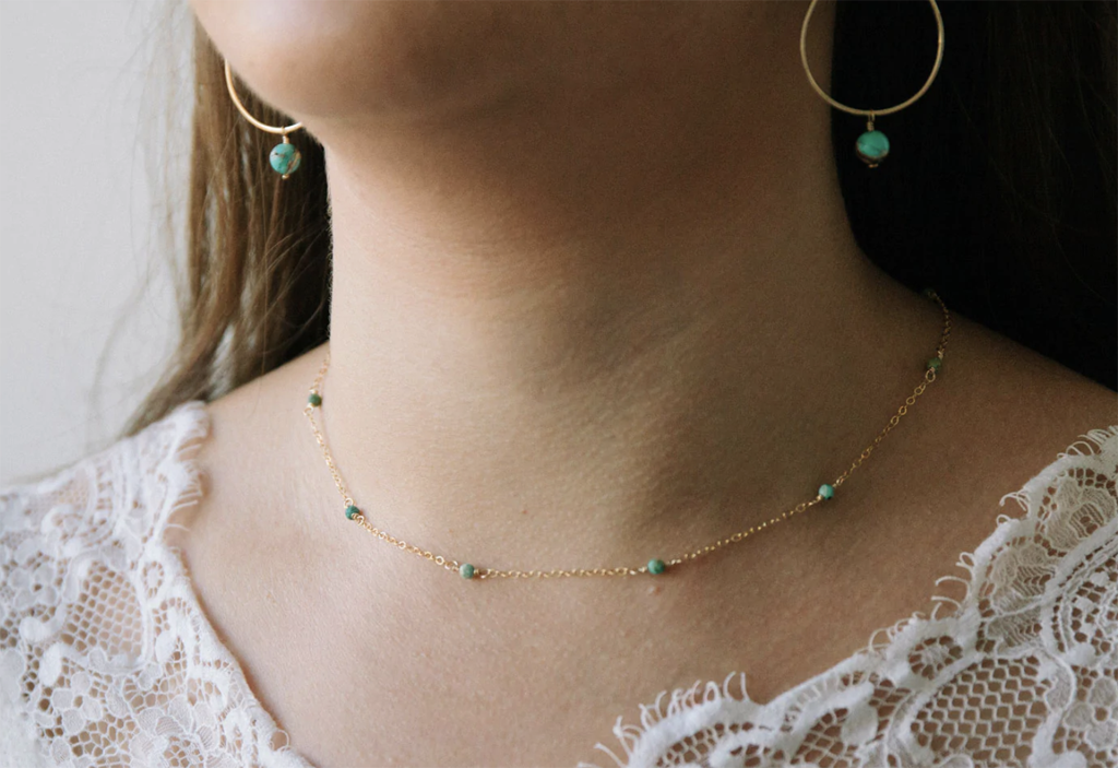 woman wearing dainty turquoise necklace and earrings