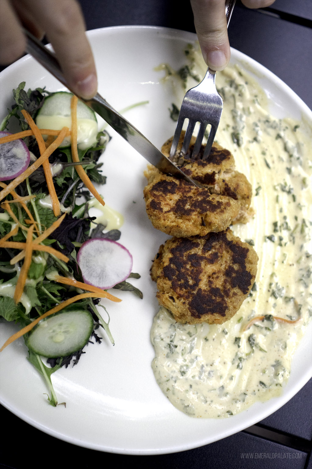 person cutting into fish cakes at a restaurant on San Juan Island