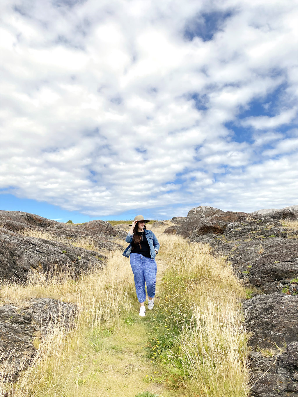 woman walking along tall grass on South Beach on San Juan Island