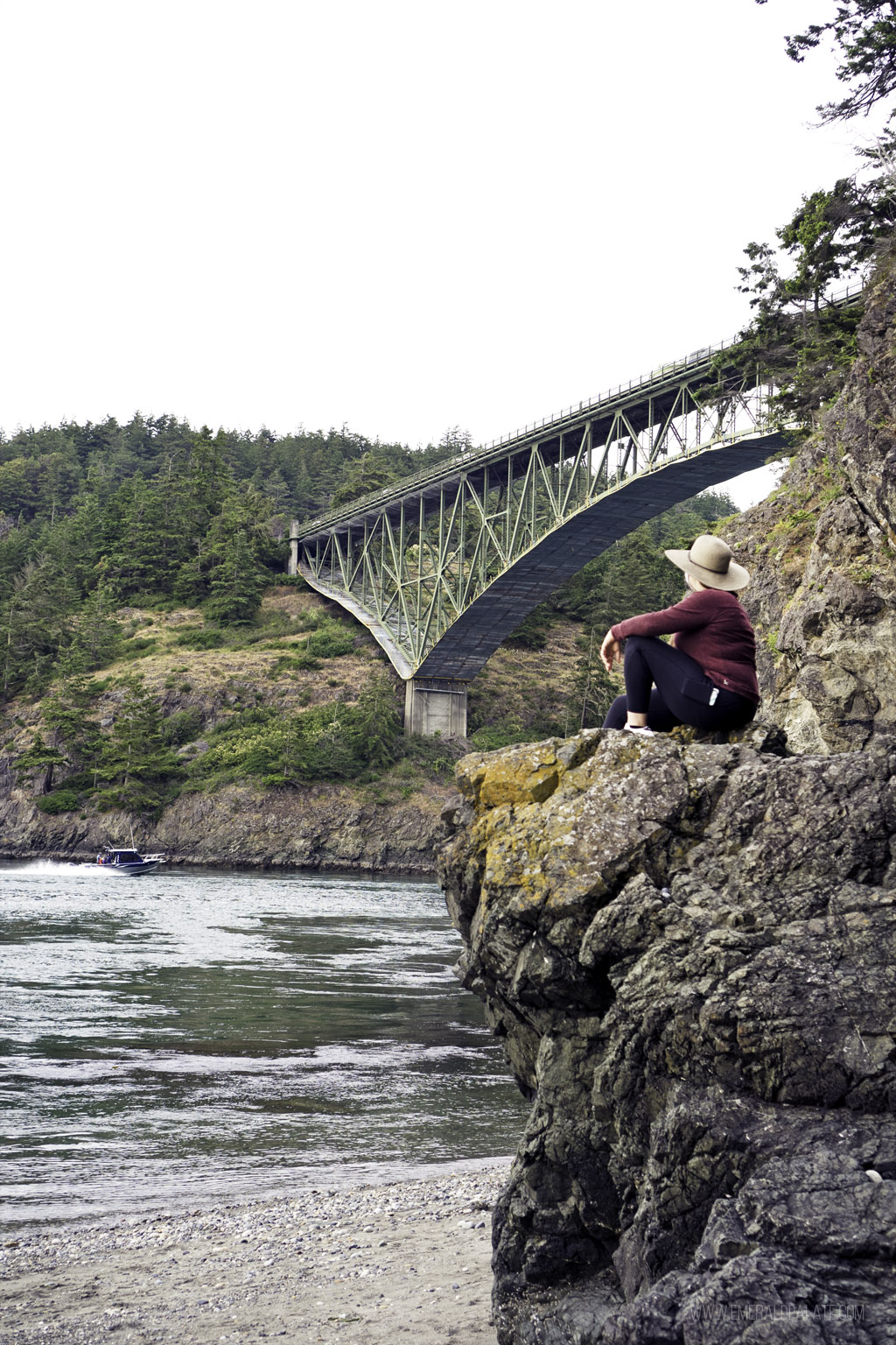 woman sitting on rock overlooking bridge on one of the islands near Seattle