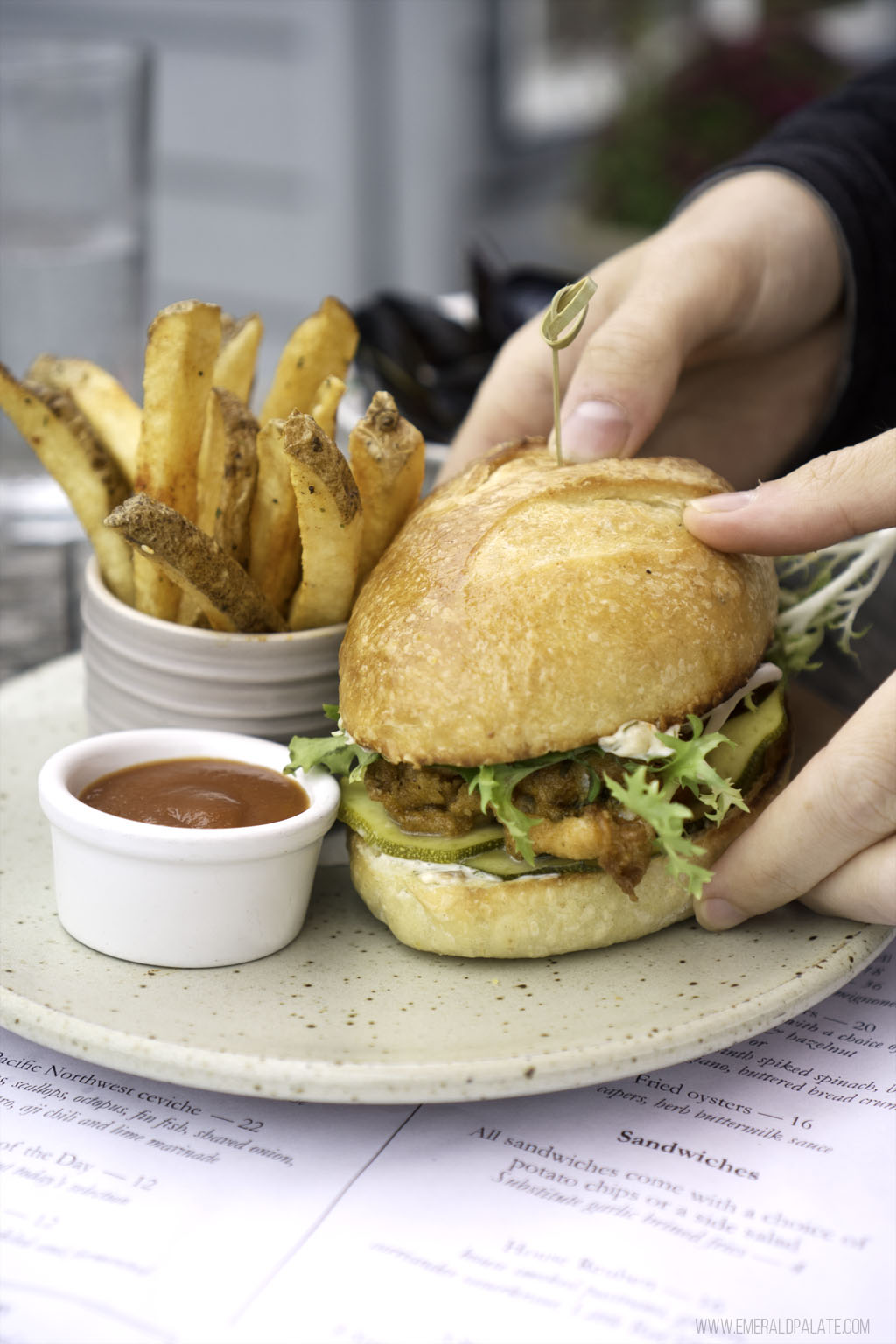 person picking up oyster po boy at one of the best restaurants on Whidbey Island