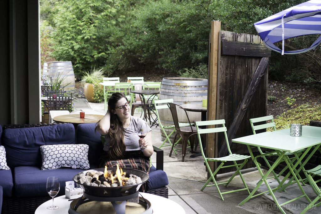 woman drinking wine on patio at Fletcher Bay Winery, one of the best wineries on Bainbridge Island