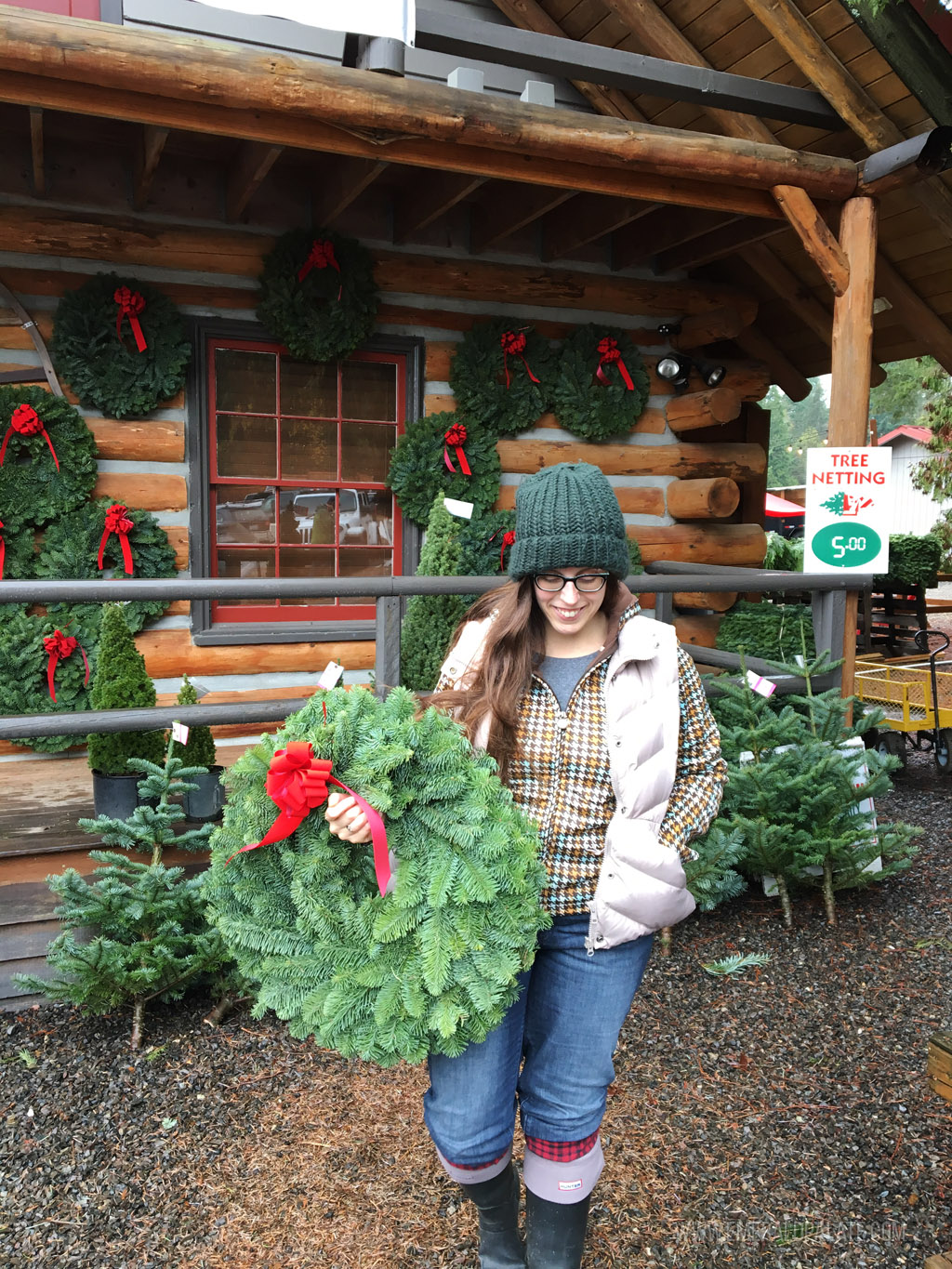 woman buying a wreath at a tree farm near Seattle