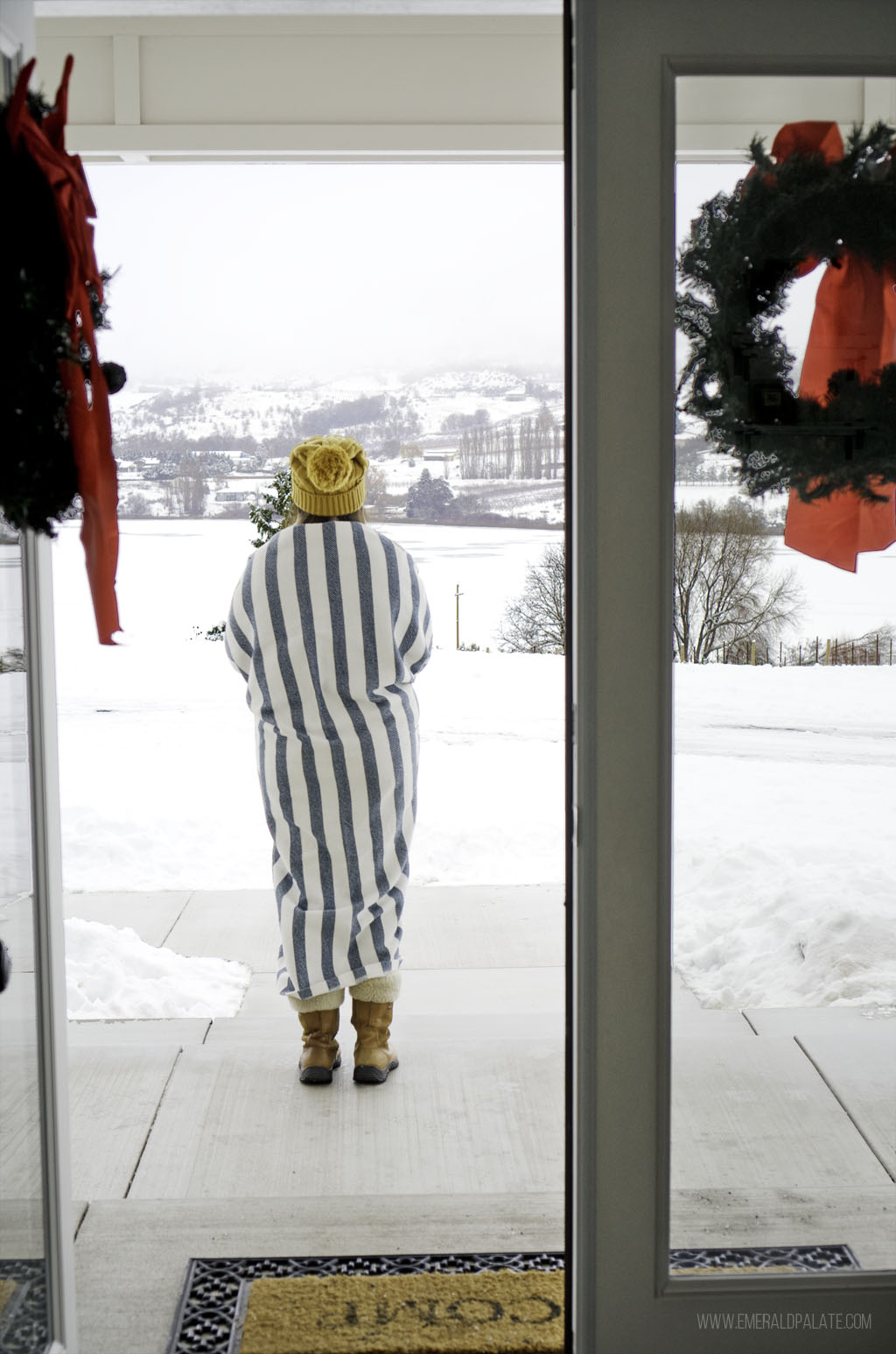 woman looking out to snowy landscape in winter