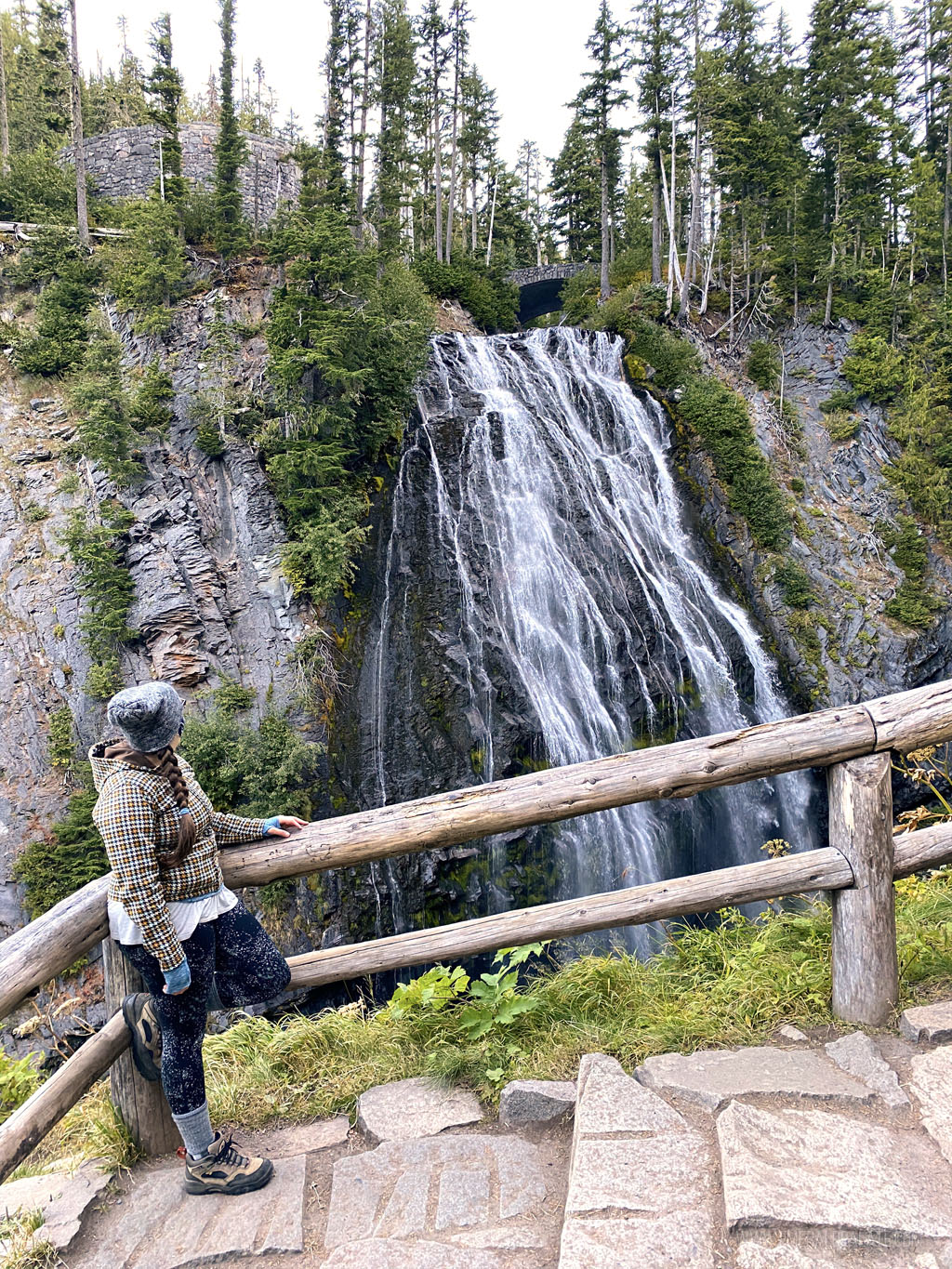 woman looking at Narada Falls from viewpoint, one of the best hikes at Mount Rainier National Park