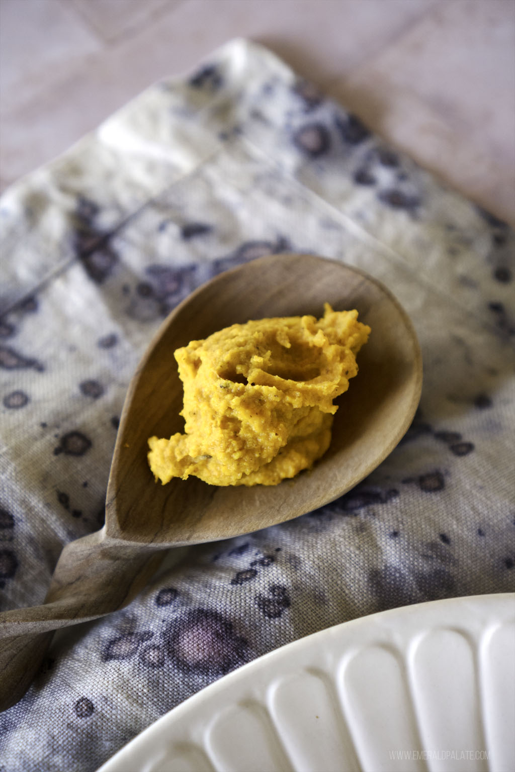 close up of butternut squash and carrot mash on a wooden spoon