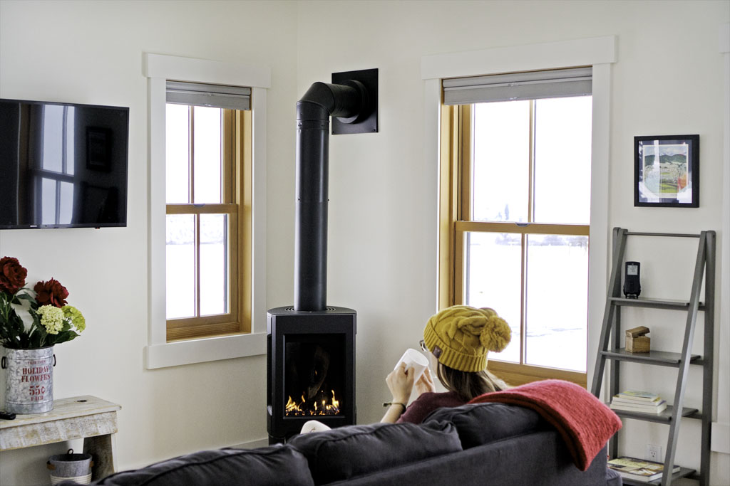 woman sipping coffee in front of a fireplace