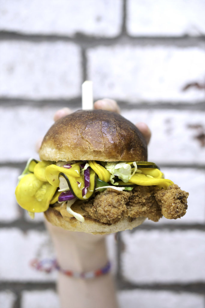 person holding fried chicken sandwich