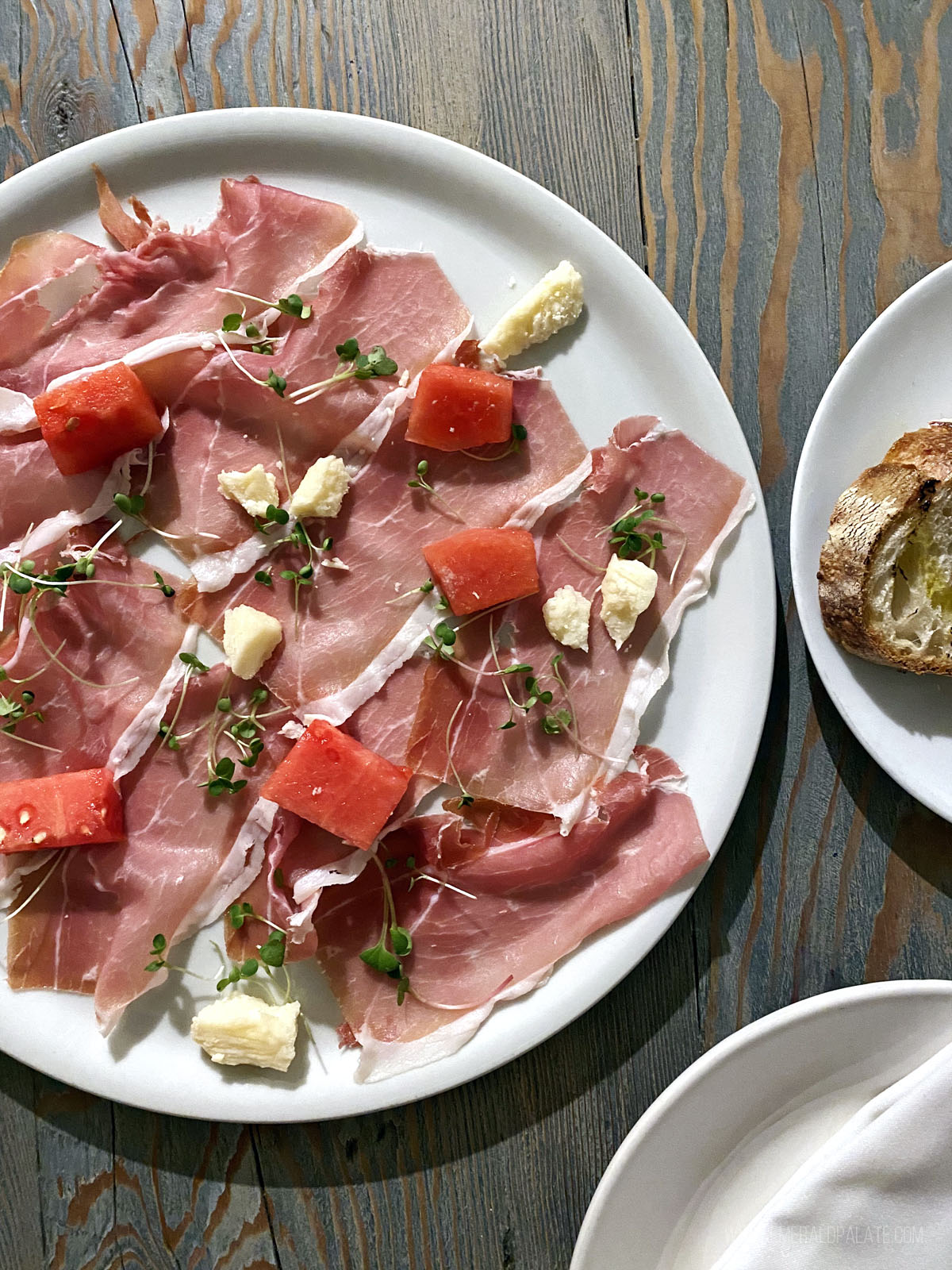 plate of prosciutto, cheese, and fruit
