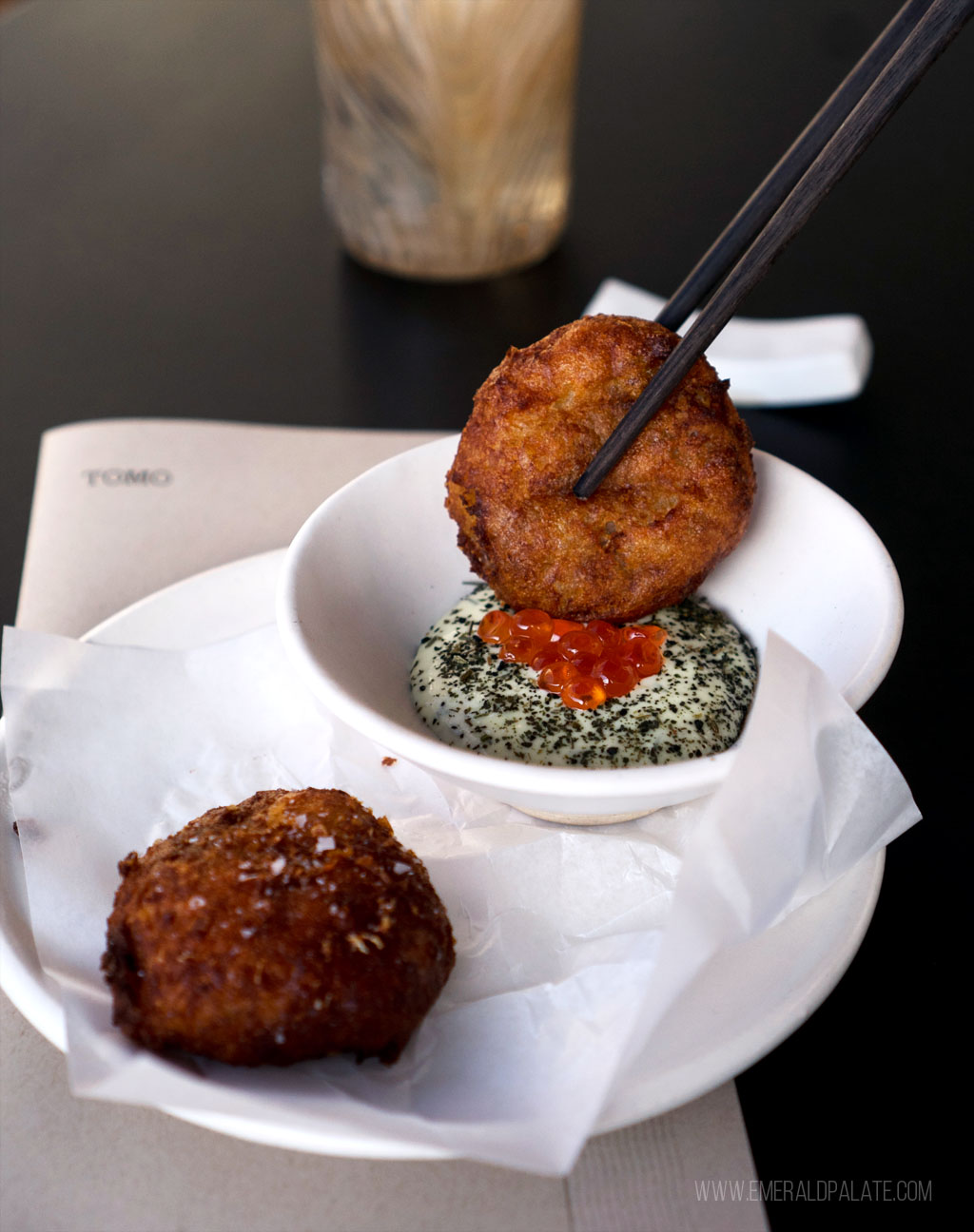 potato cake with caviar being dipped in a dill sauce