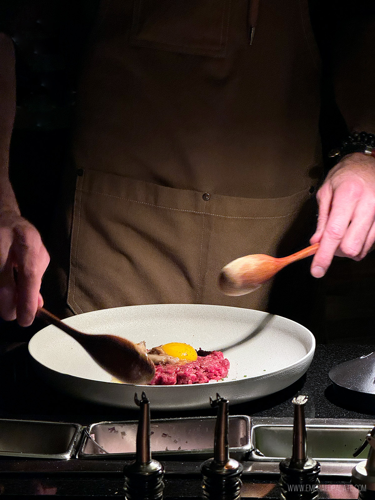 chef about to mix steak tartare with an egg on it