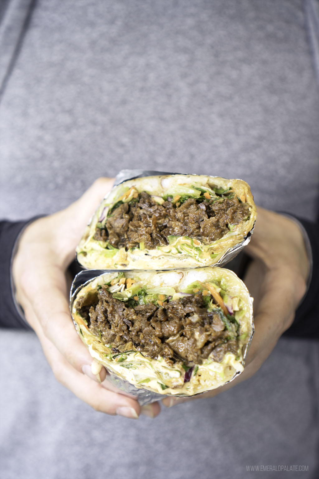 person holding beef bulgogi sub halves