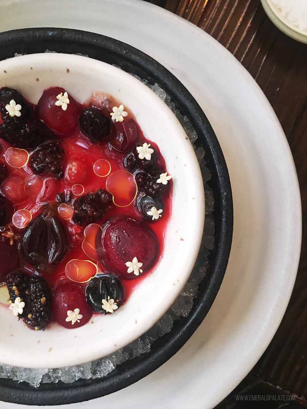 bowl of berries with tiny flowers on it from a fine dining restaurant that would make a great romantic date in Seattle