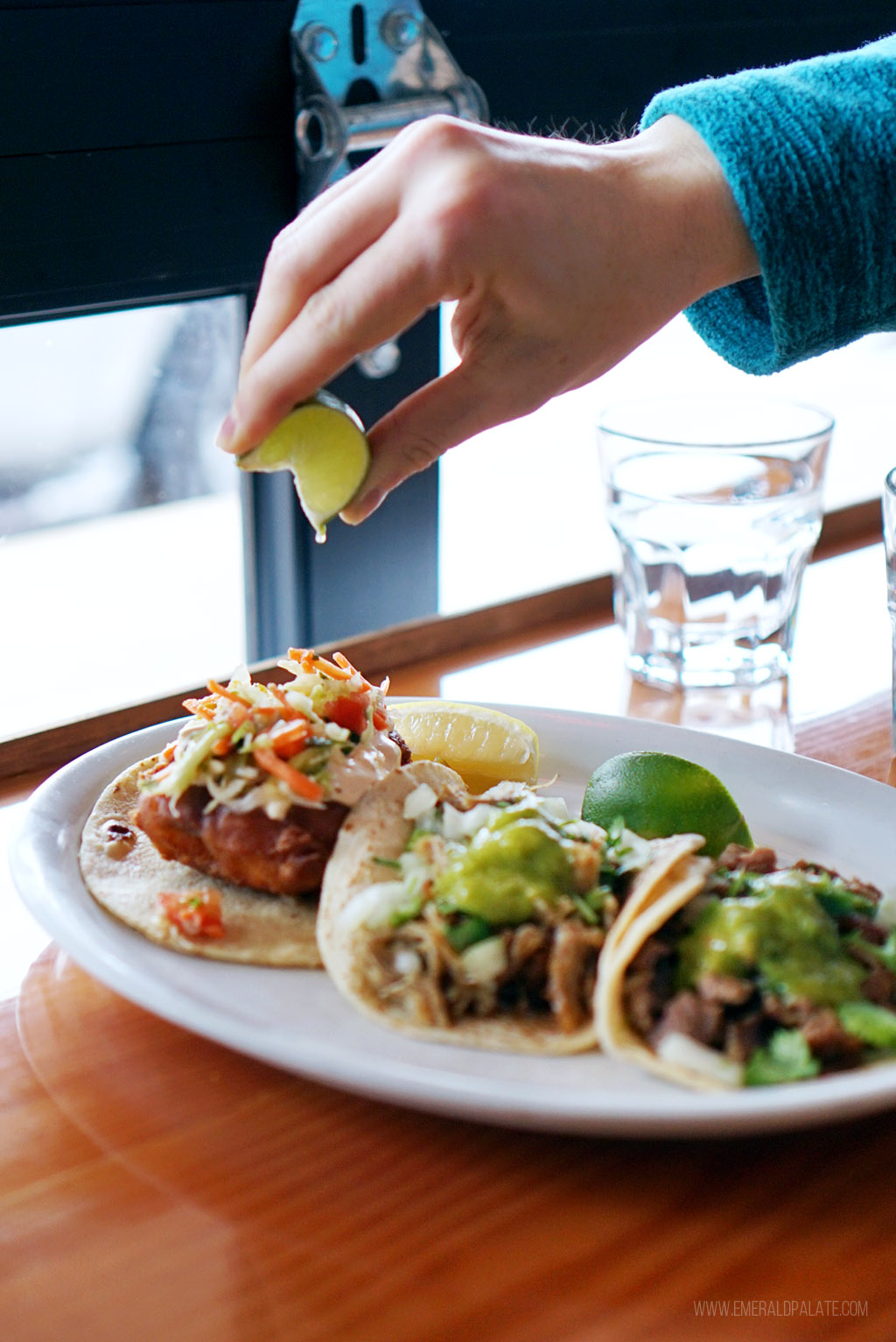 person squeezing lime over fish tacos in Lake Chelan