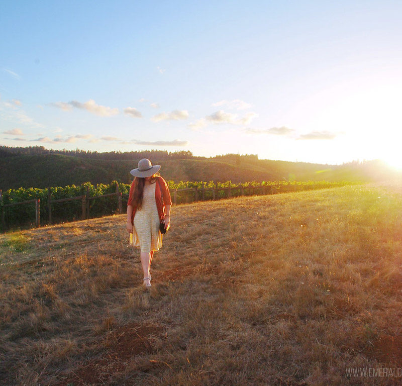 woman walking in the vineyards at sunset at King Estate Winery outside Eugene OR