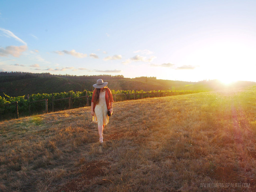 woman walking in the vineyards at sunset at King Estate Winery