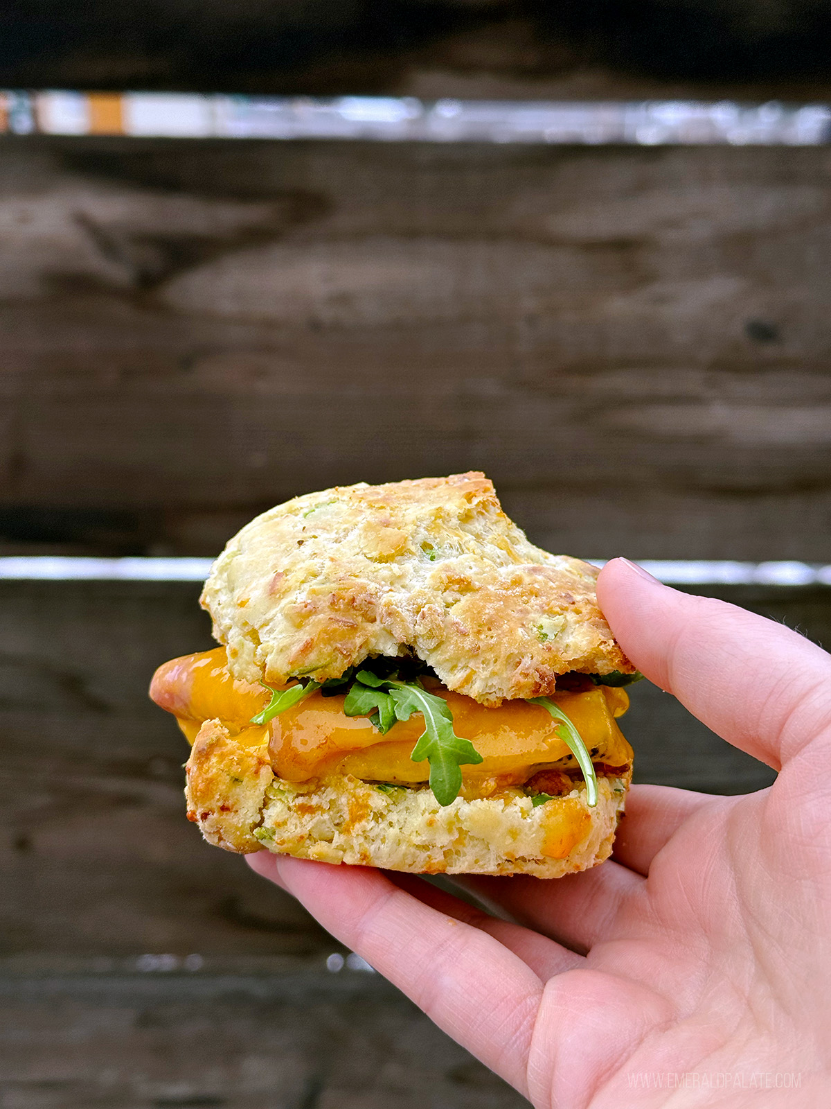 person holding up a biscuit breakfast sandwich