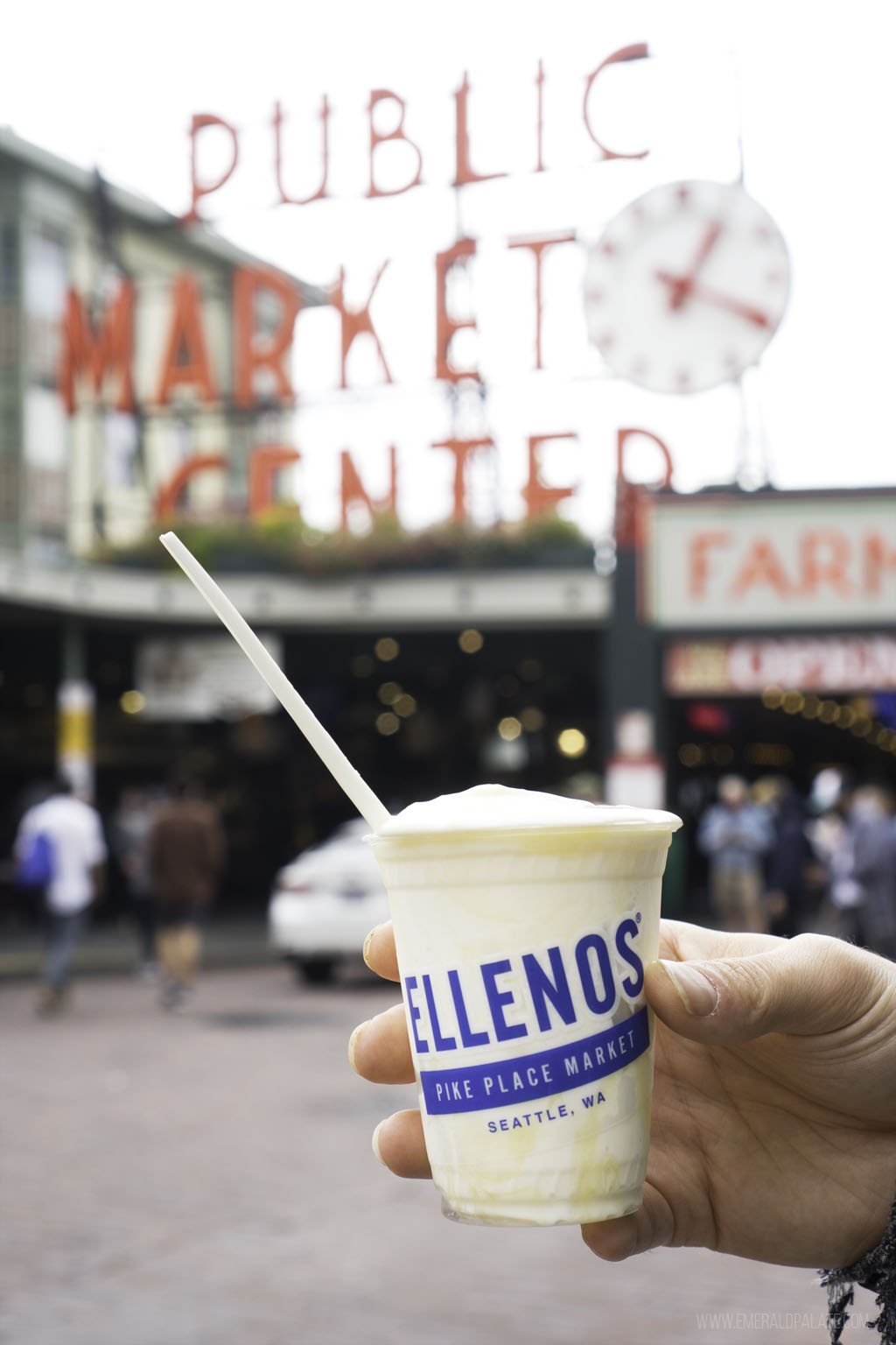 person holding yogurt in front of Pike Place Market, quintessential Seattle food