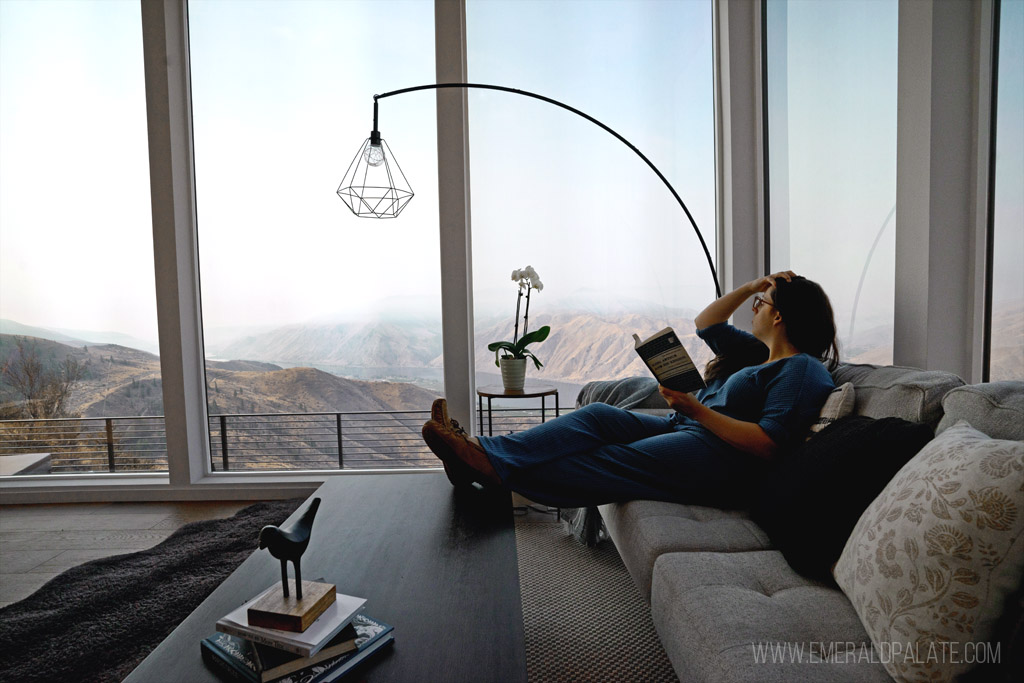 woman on a couch overlooking a valley at one of the most romantic Airbnbs in Washington state