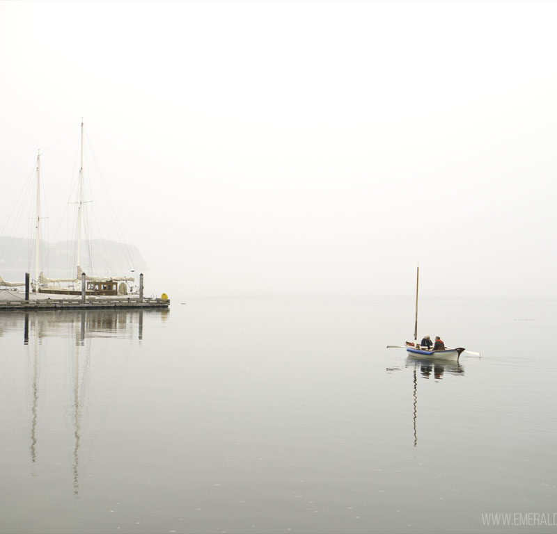 older men canoeing on the water near a dock in the mist on Whidbey