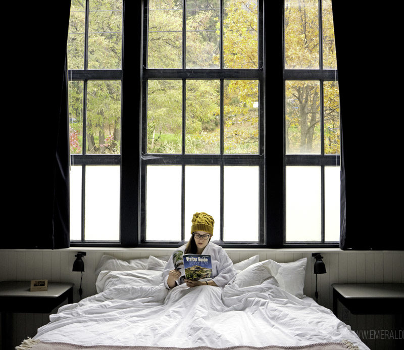 woman reading in bed at a hotel in Columbia River Gorge