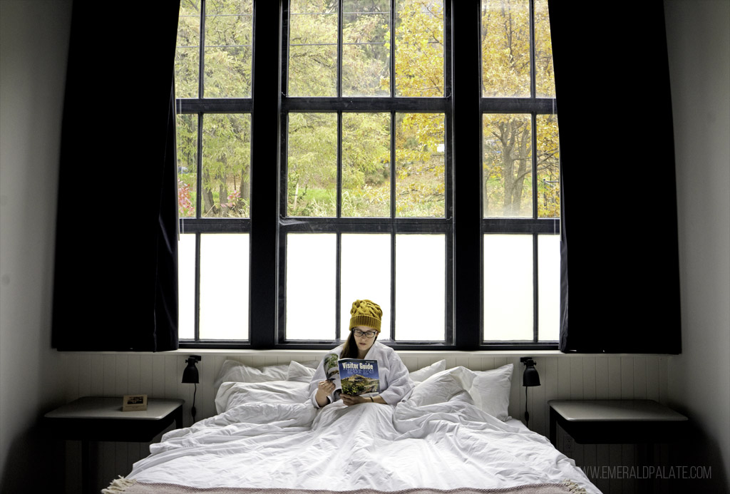 woman reading in bed at a hotel in Columbia River Gorge