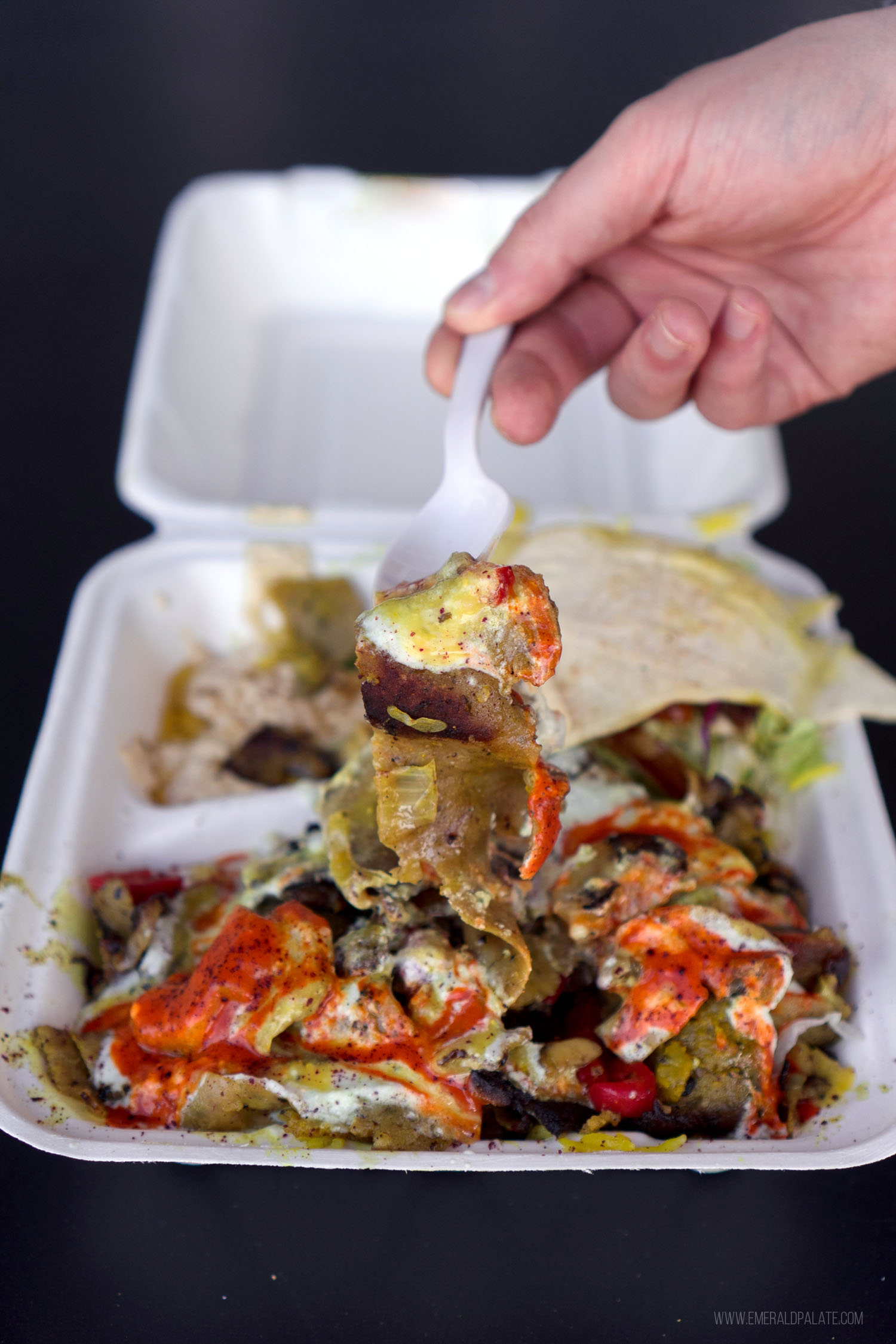 person picking up halal food in Seattle with a fork