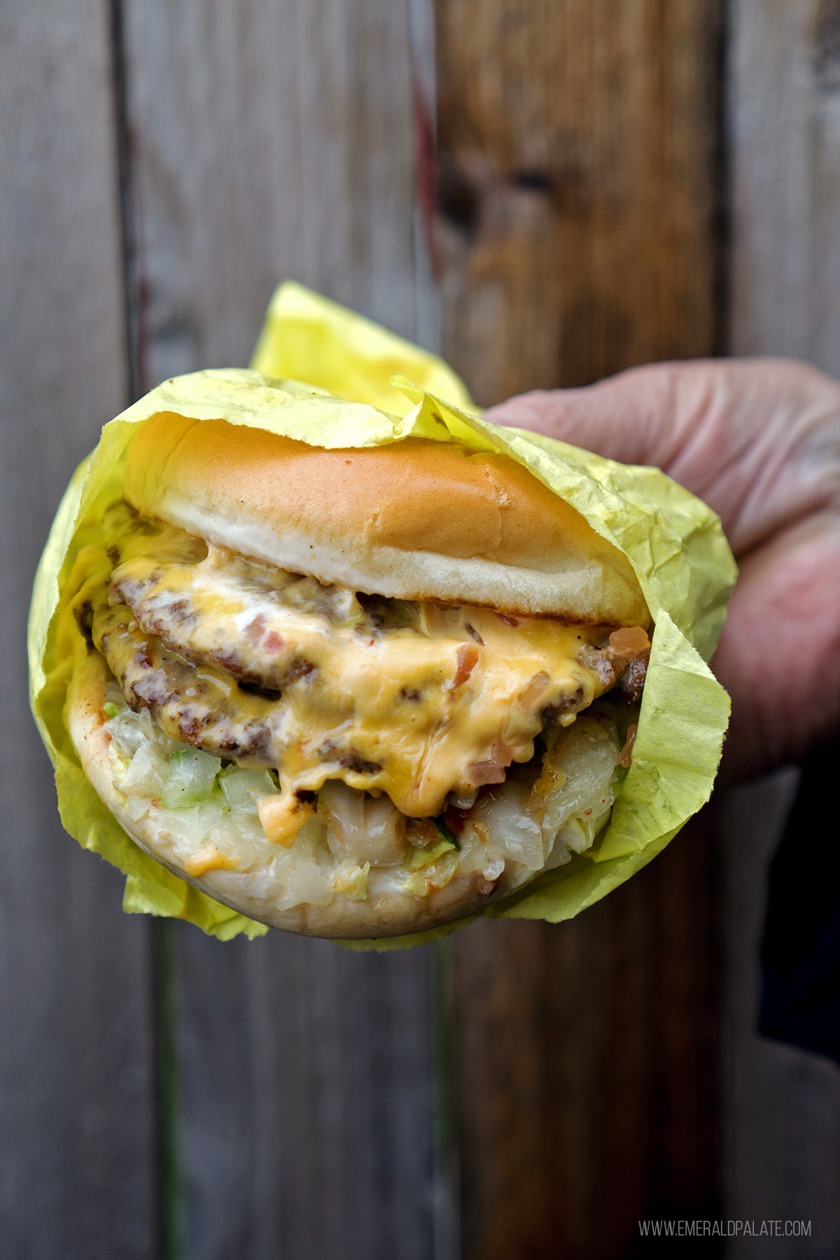 person holding a cheeseburger from one of the best restaurants on Vashon Island