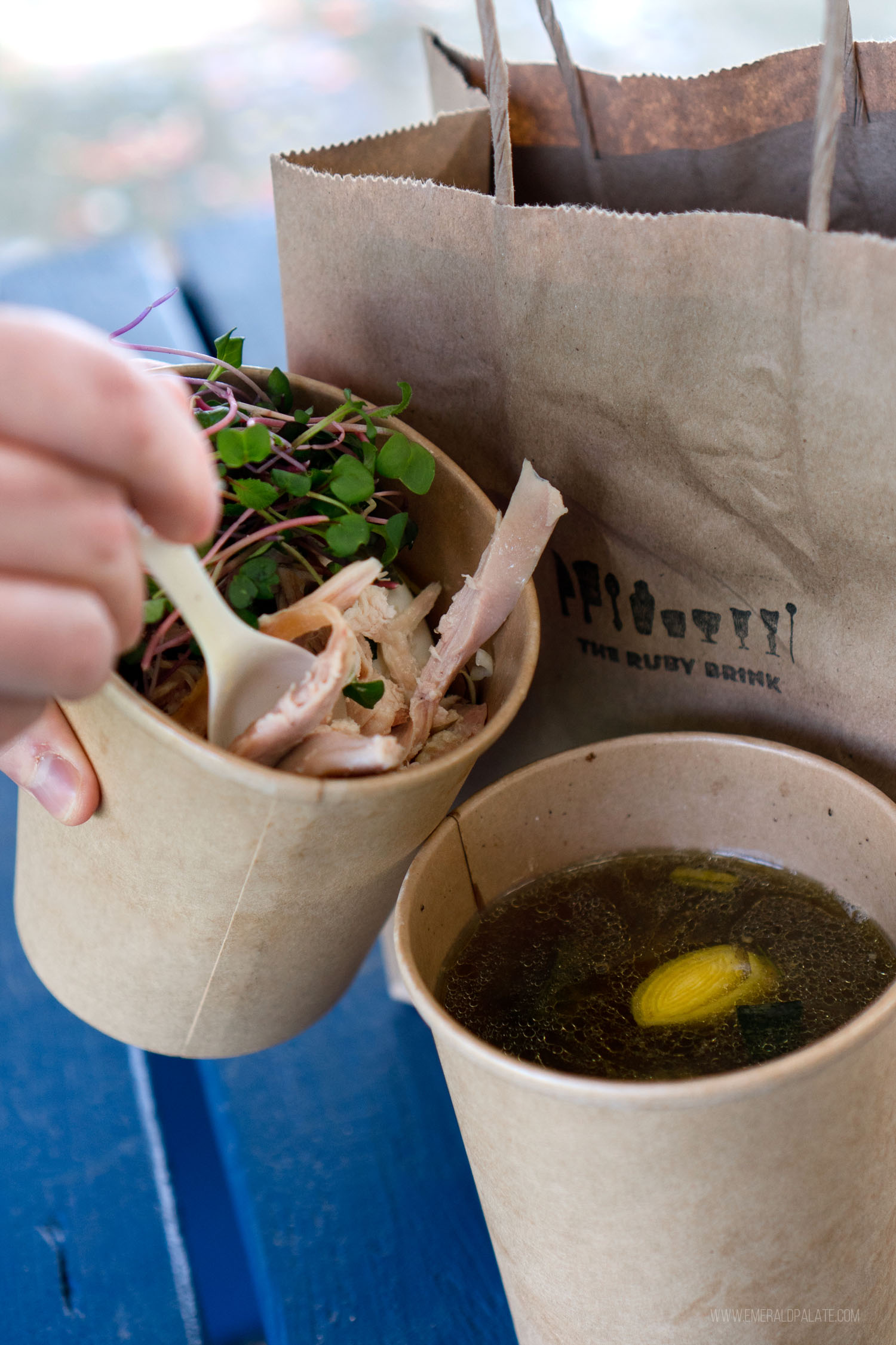 person pouring soup into a takeout container from a restaurant on Vashon Island, WA