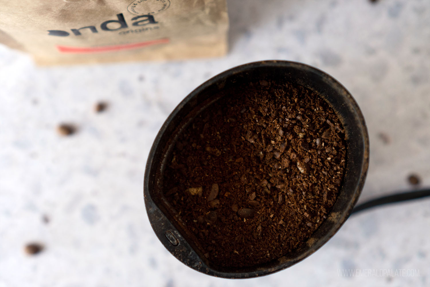 ground coffee in a grinder ready to be poured into a French press