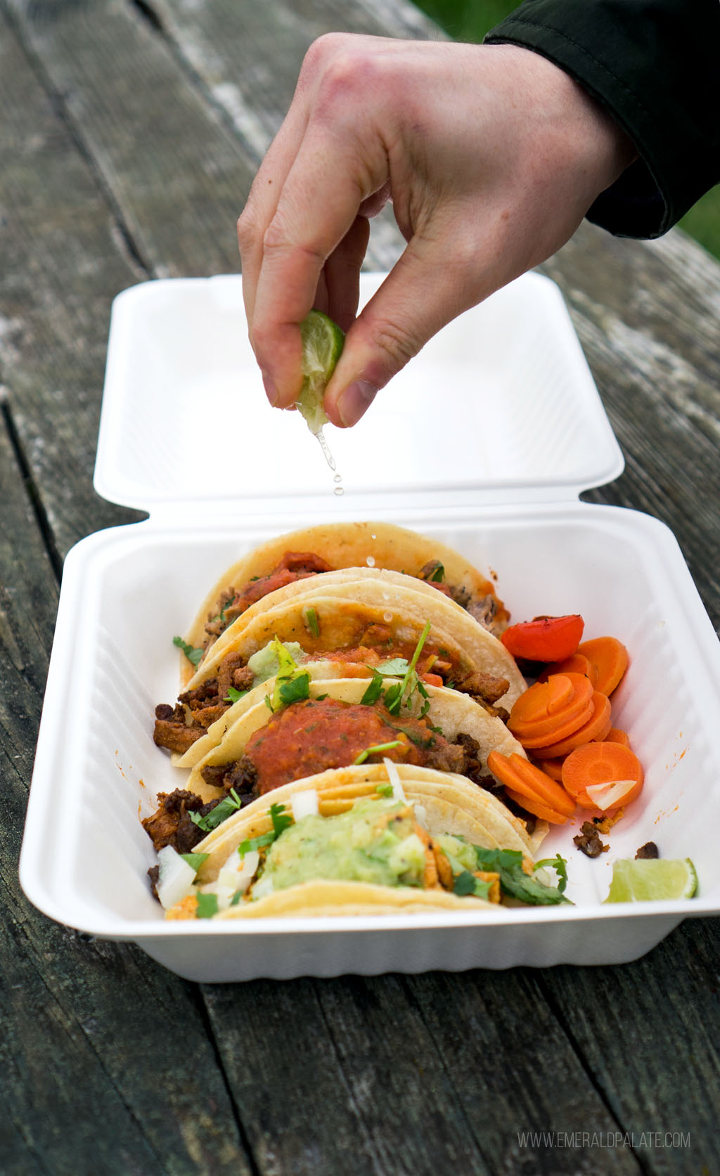 person squeezing lime over tacos from a takeout spot on Lopez Island, WA