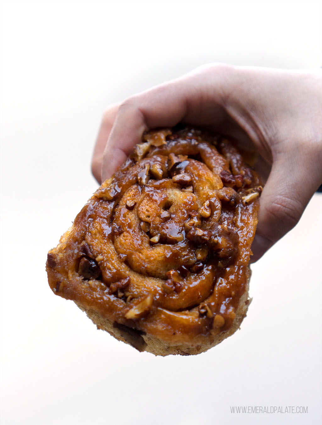 closeup of person holding cinnamon bun from a Lopez Island bakery