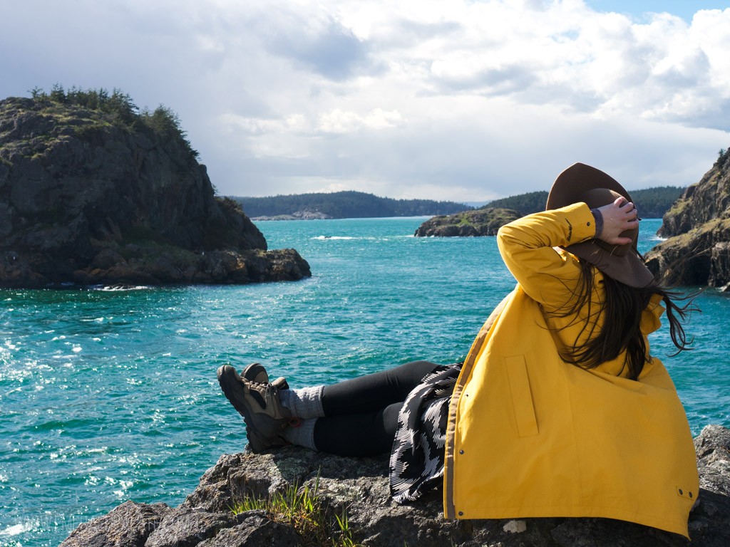 woman overlooking ocean on a cliff, one of the best things to do on Lopez Island