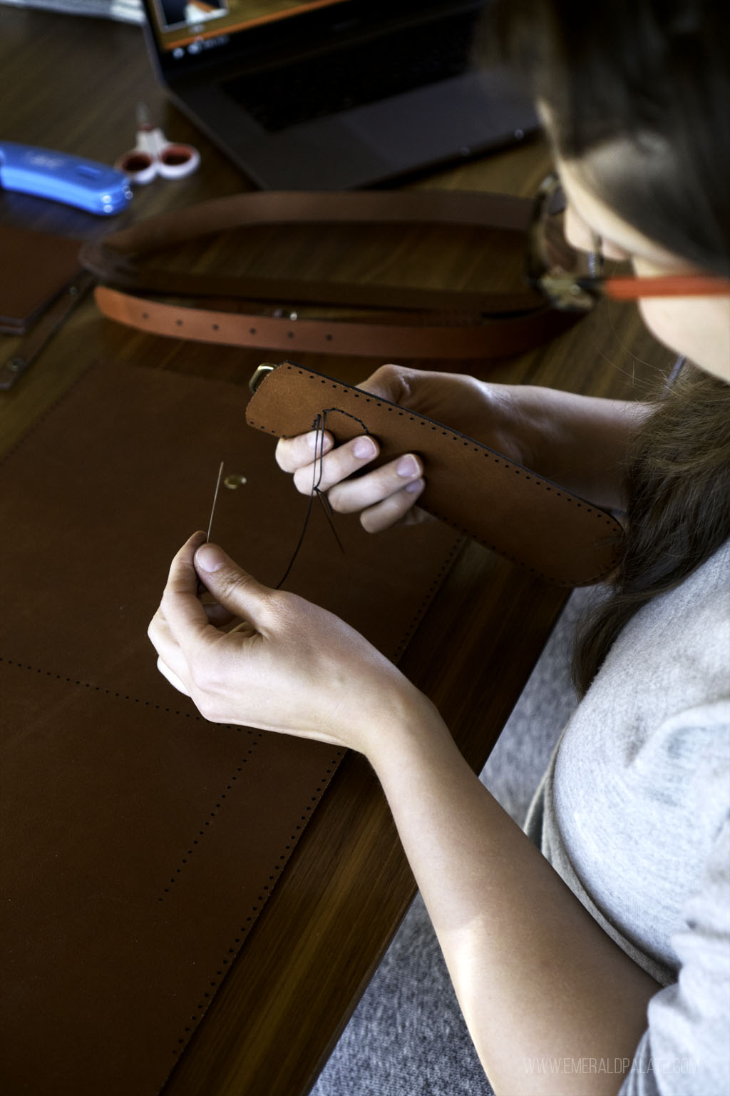 person stitching leather