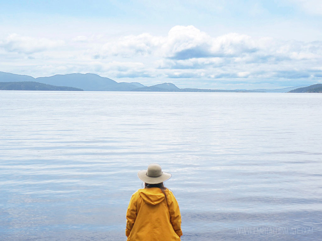 woman standing in front of lake at Larrabee Stat Park, a must do in this Bellingham guide