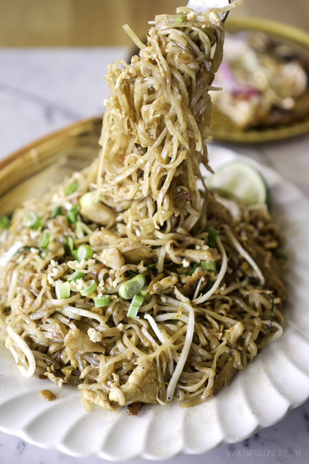 person pulling pad Thai noodles with chopsticks from a Thai restaurant in Seattle