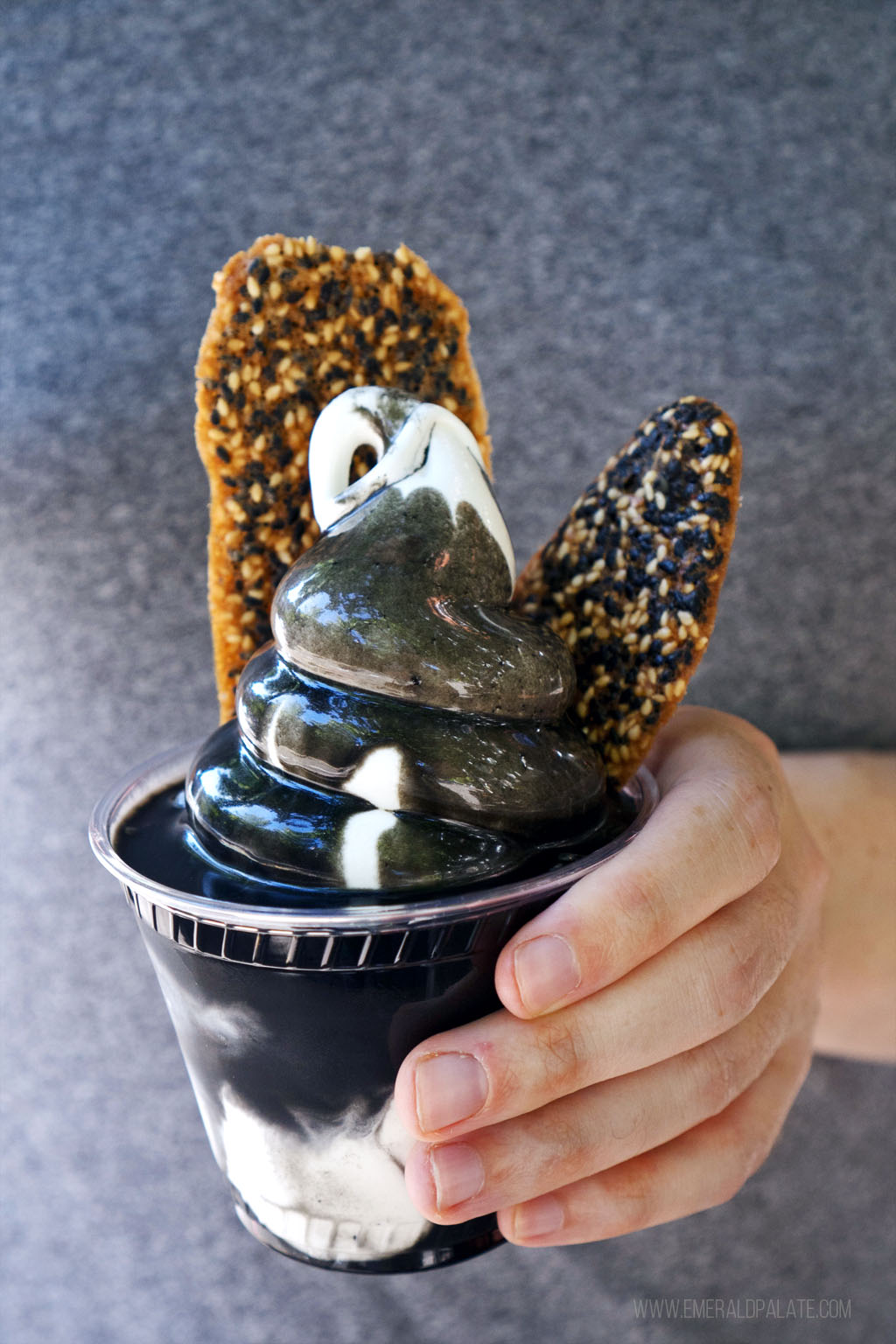 black sesame cookies in a cup with soft serve ice cream topped with sesame sauce