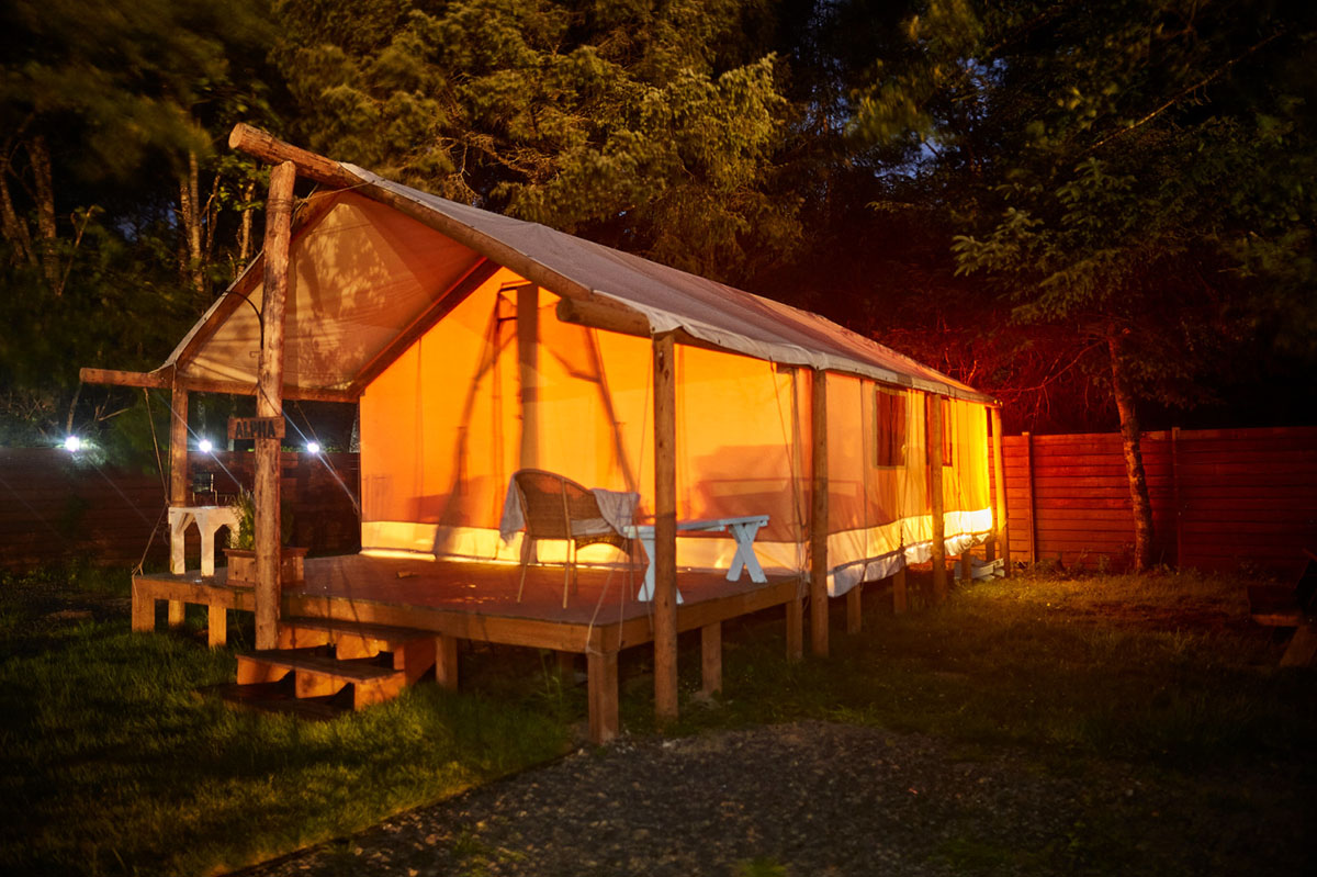 safari glamping tent lit up at night