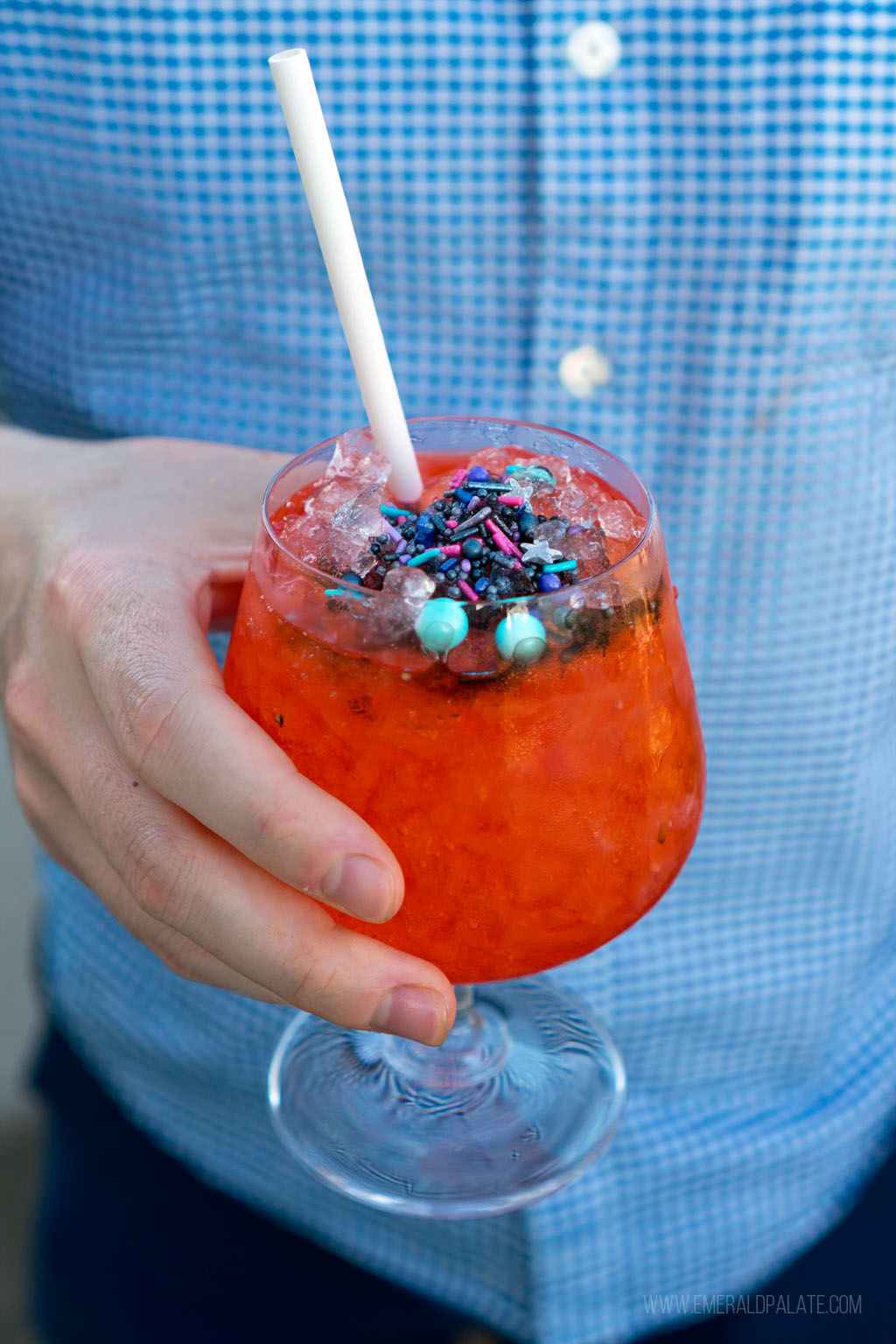 person holding a cocktail with sprinkles