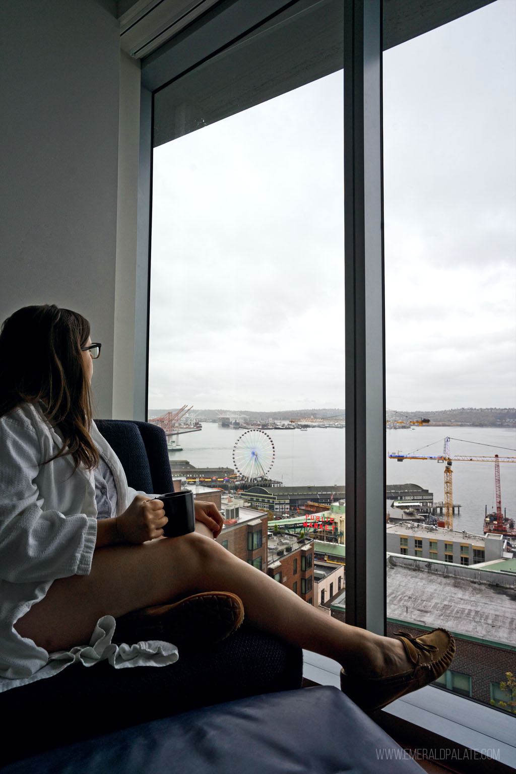 woman looking out at Seattle waterfront from a cool place to stay in Seattle