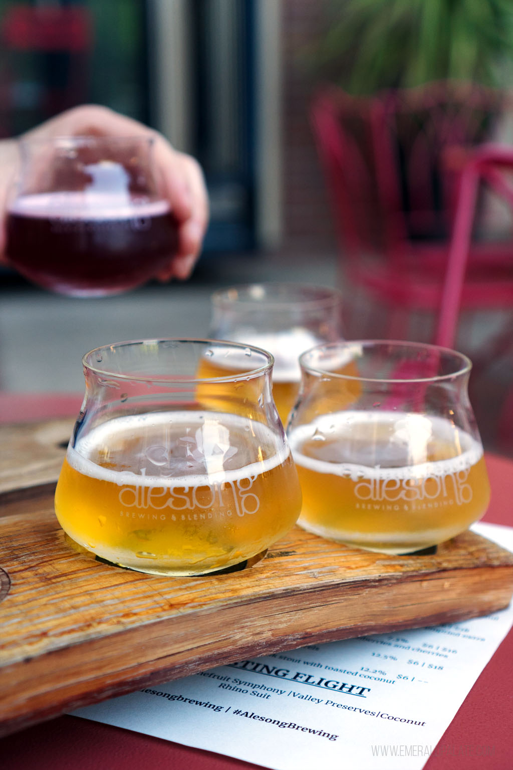 person grabbing a tasting glass from a flight at a brewery in 5th Street Public Market