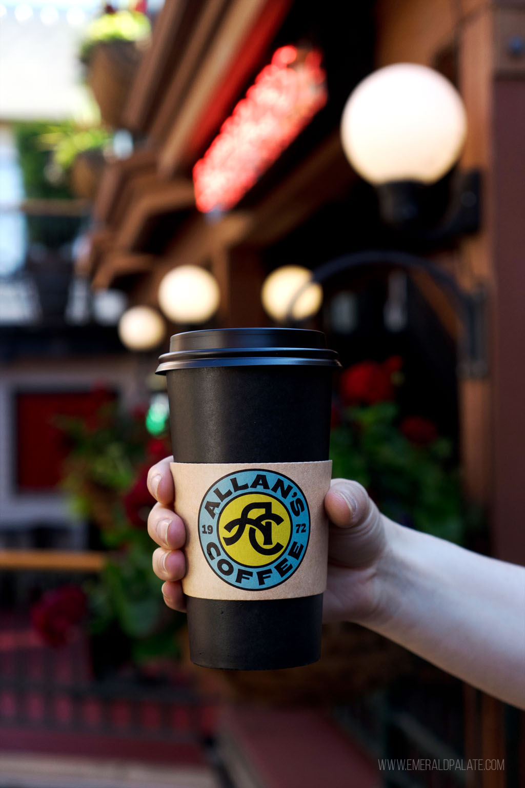 person holding a to-go coffee cup in 5th Street Public Market