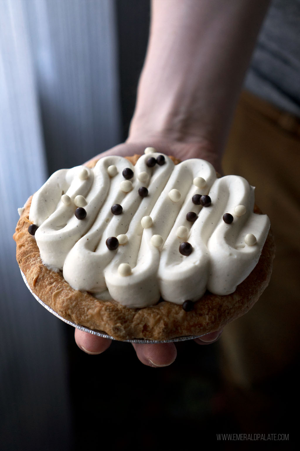 person holding a mini banana cream pie from Eugene, Oregon bakery