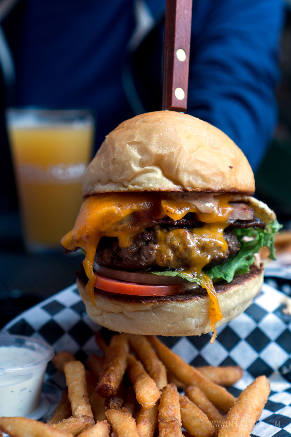 person holding burger from 5th Street Public Market in Eugene, Oregon