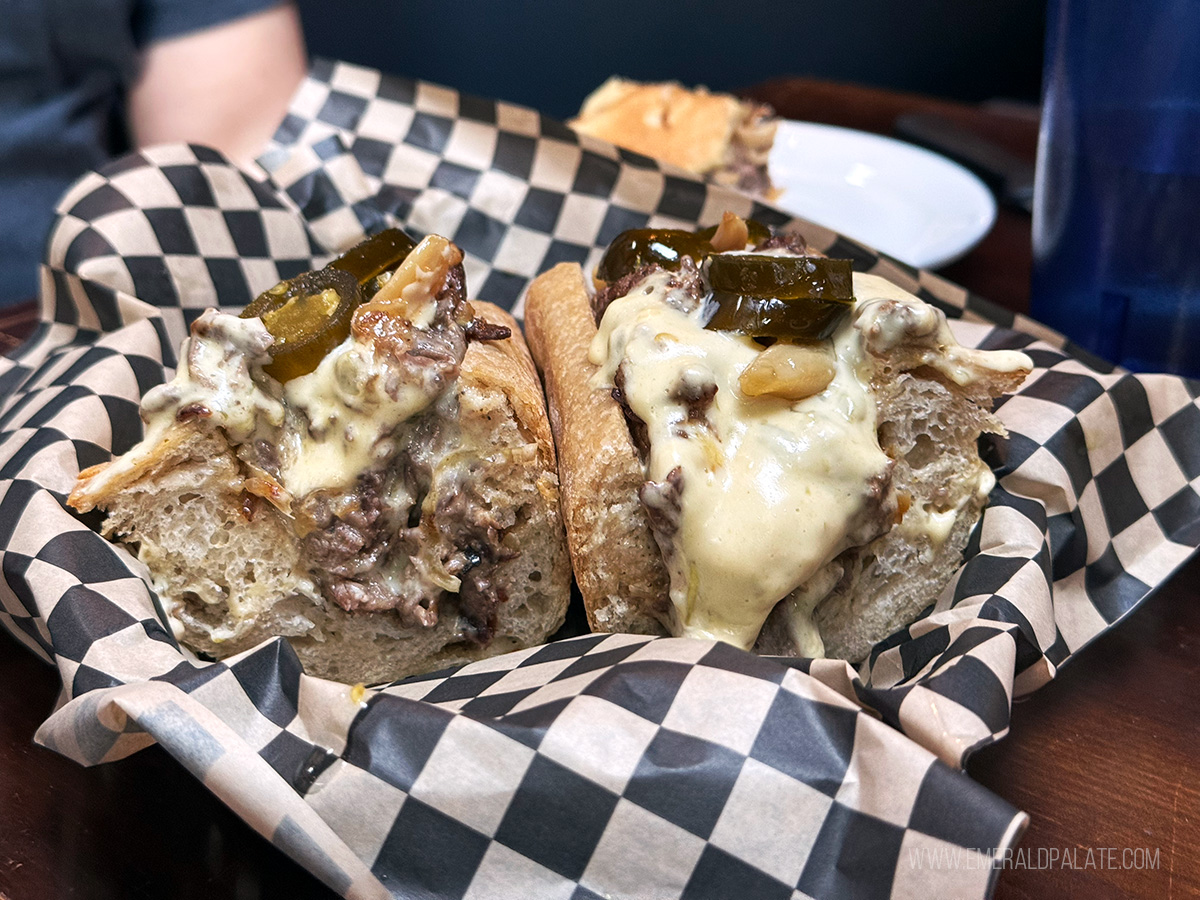 Cheesesteak halves open and oozing with cheese, one of the best sandwiches in Seattle