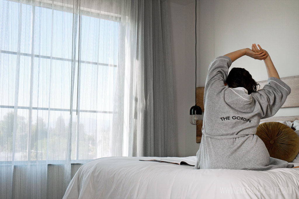 woman stretching while in bed at a boutique hotel in Eugene