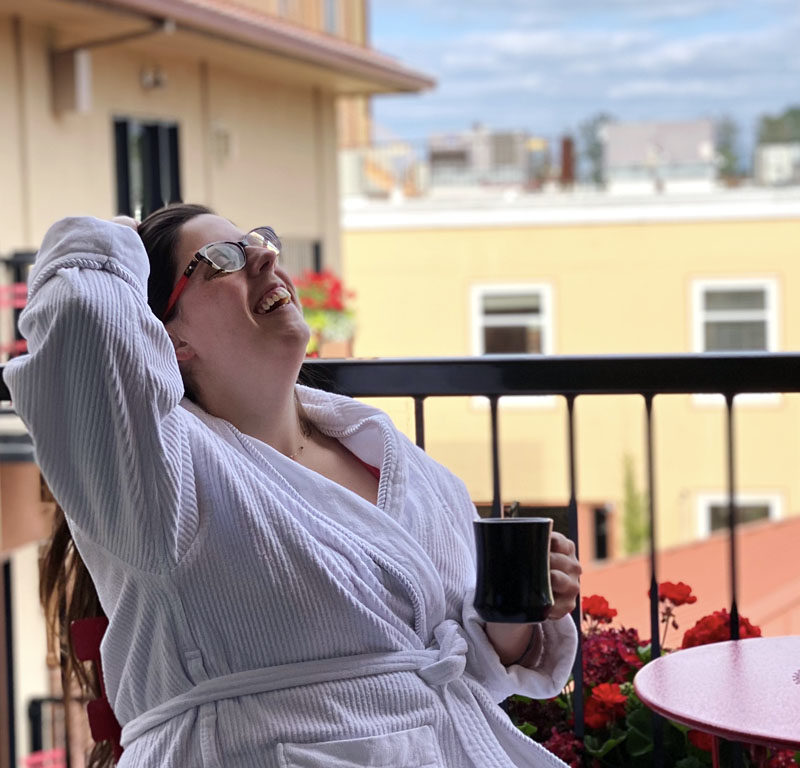 woman laughing on balcony of one of the best boutique hotels in Eugene, Oregon