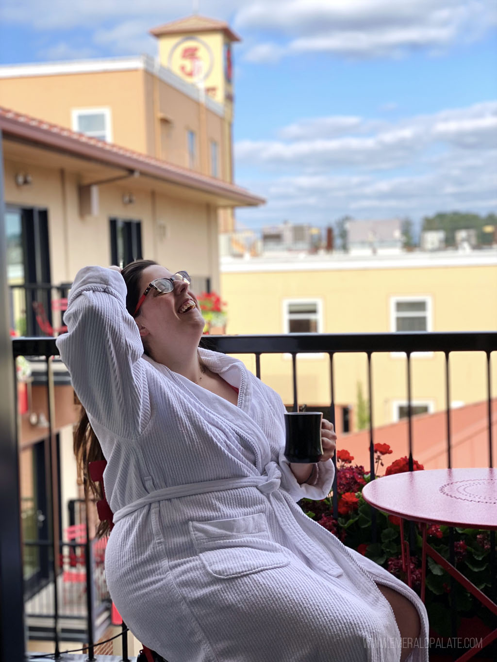 woman in robe drinking coffee on a hotel balcony