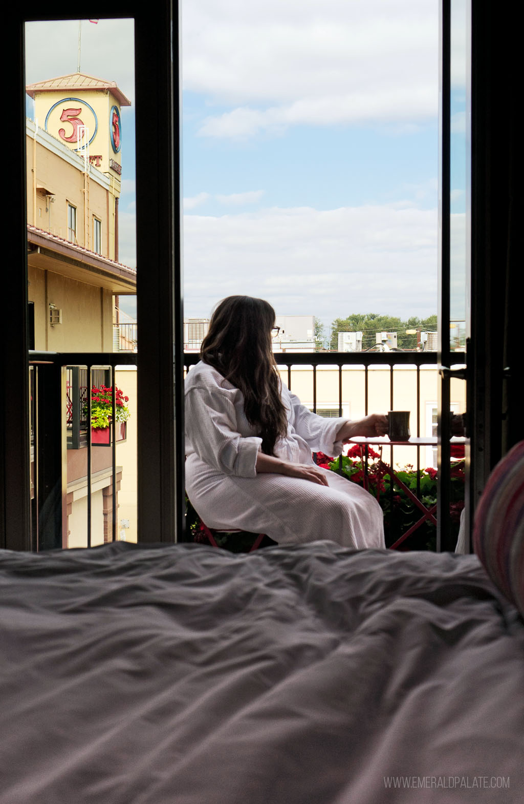 woman sitting on balcony in a robe at one of the best Eugene boutique hotels